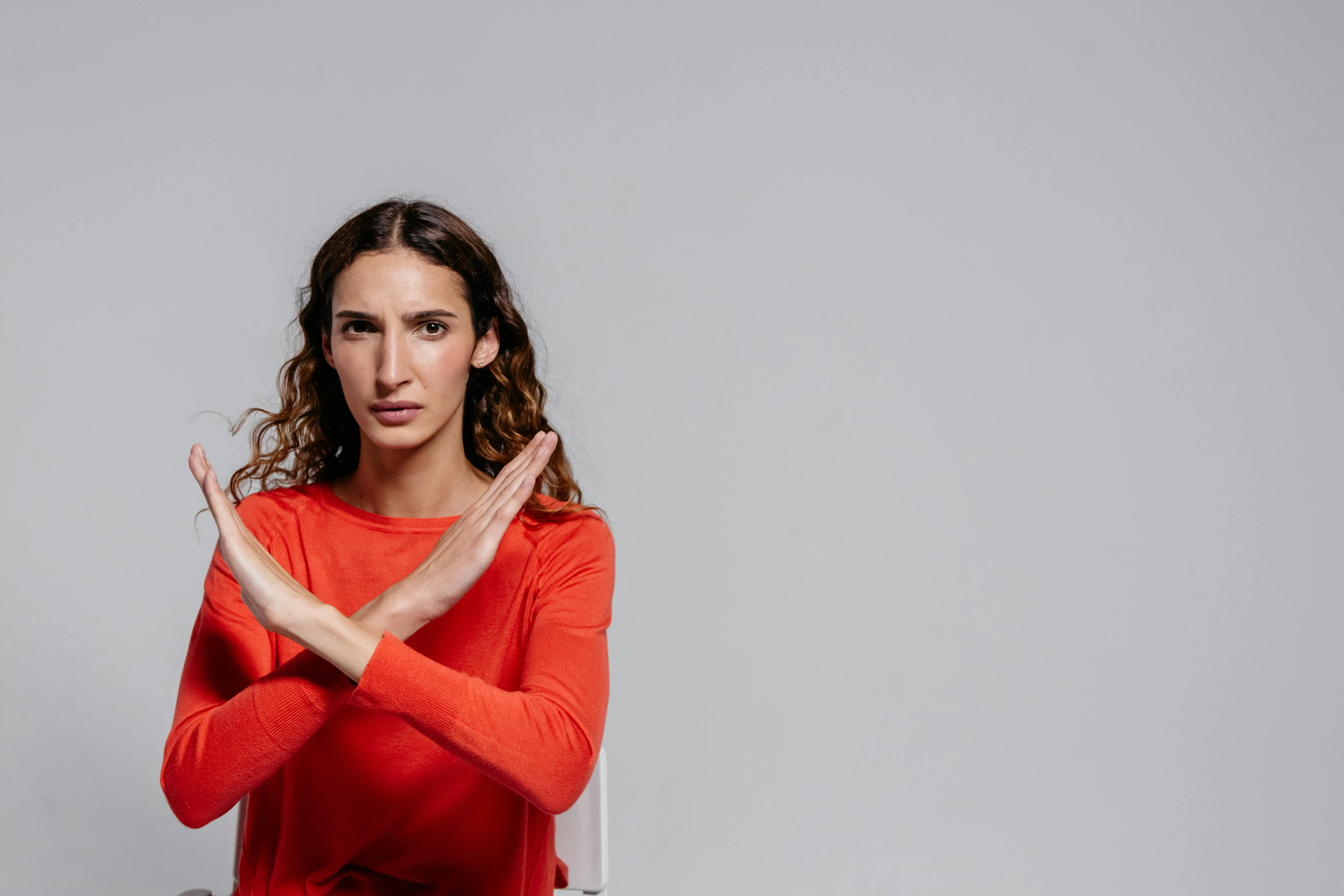 A woman crosses her arms, signalling she does not want to be touched