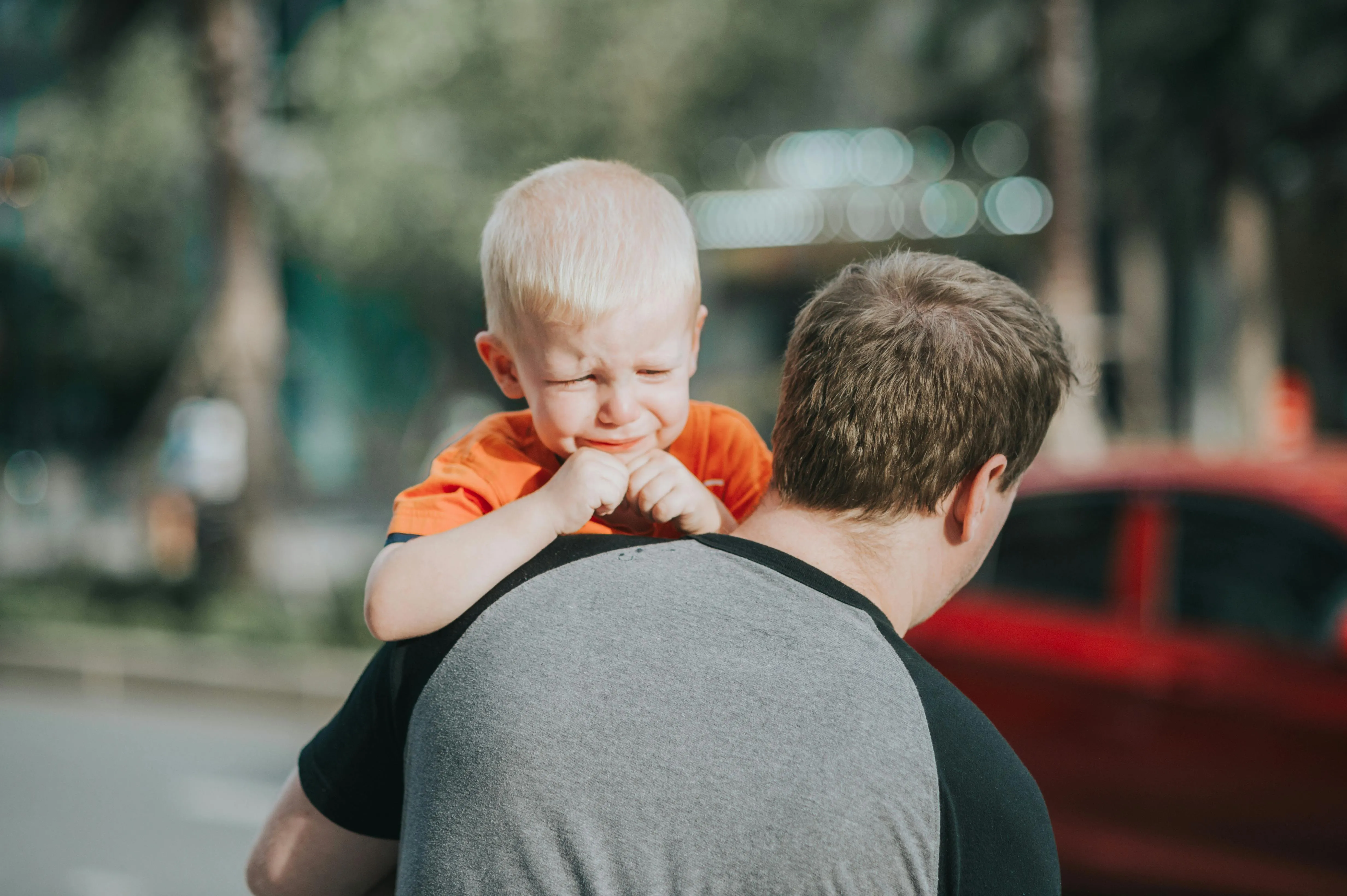 An adult grips a boy by the shoulders