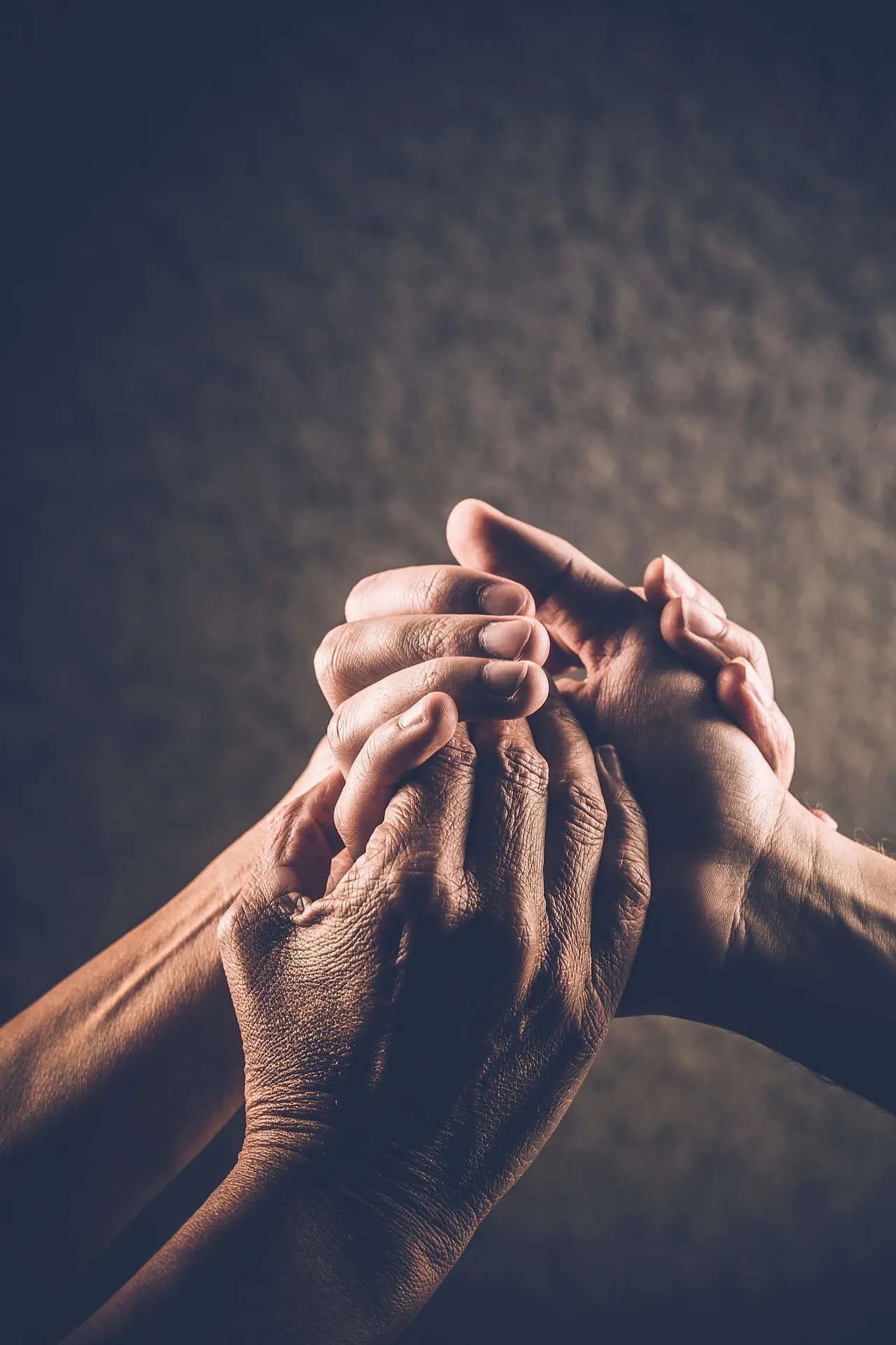 Many hands reaching in to hold each other