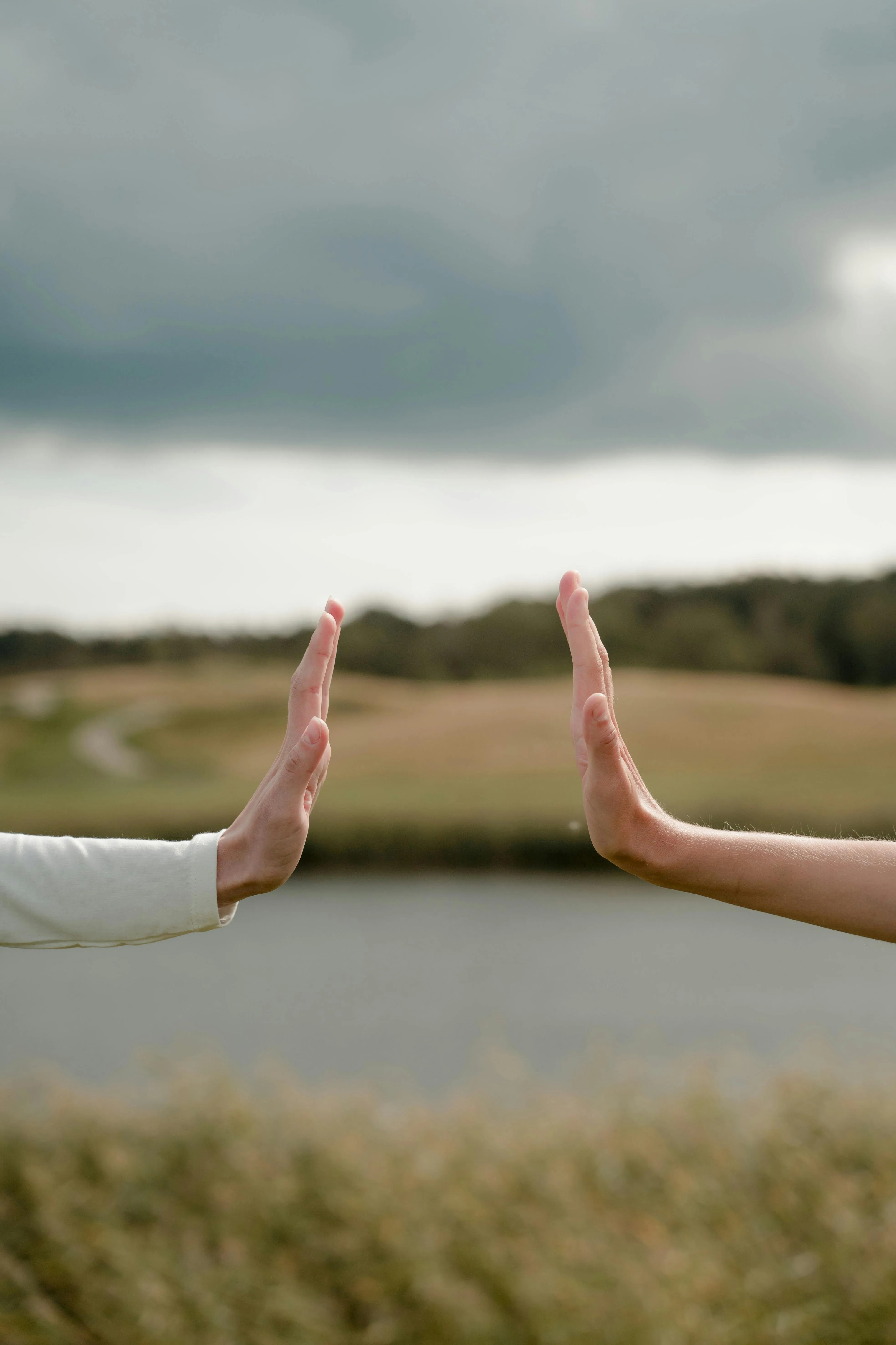 Two people facing each other with hands extended in a stalemate